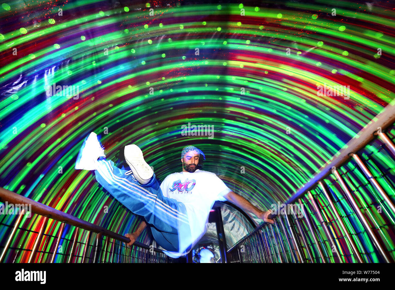 Breakdancer B-Boy Sette da 360 Allstar esegue alcuni trucchi di basket in le luci luminose del moto vorticoso tunnel di turbolenza in Camera Obscura & World of Illusions, Edimburgo, davanti a loro Edinburgh Festival Fringe mostrano. Foto Stock