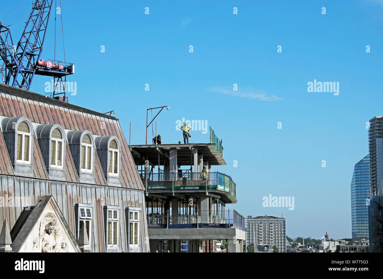 Vista della costruzione i lavoratori che operano sul piano superiore del Denizen alto edificio di appartamenti in Golden Lane London EC2 Inghilterra UK KATHY DEWITT Foto Stock