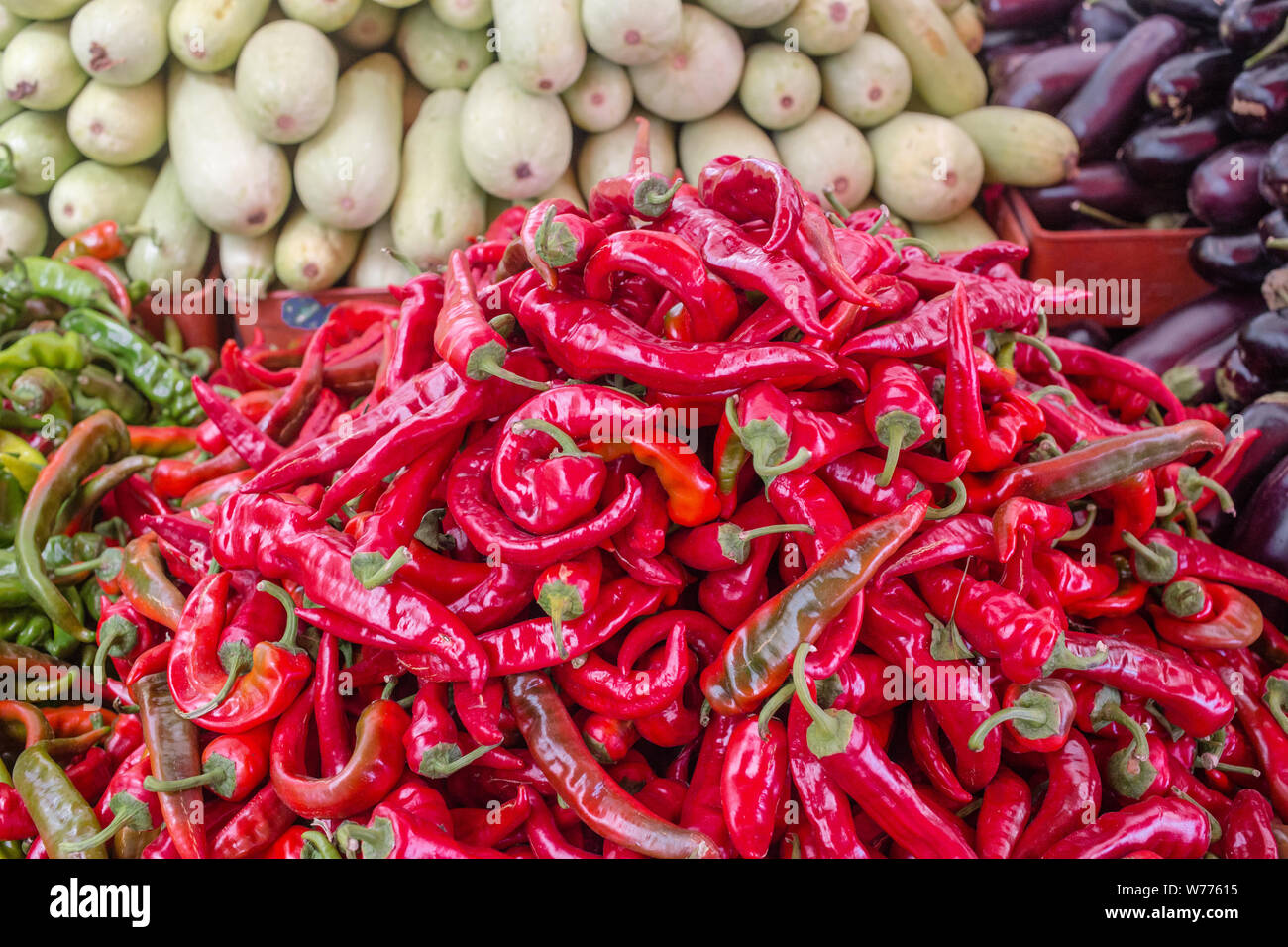Peperoni rossi texture di sfondo di peperoncino condimento fiery un piatto di in vendita. Peperone rosso su un mercato locale contatore. Foto Stock