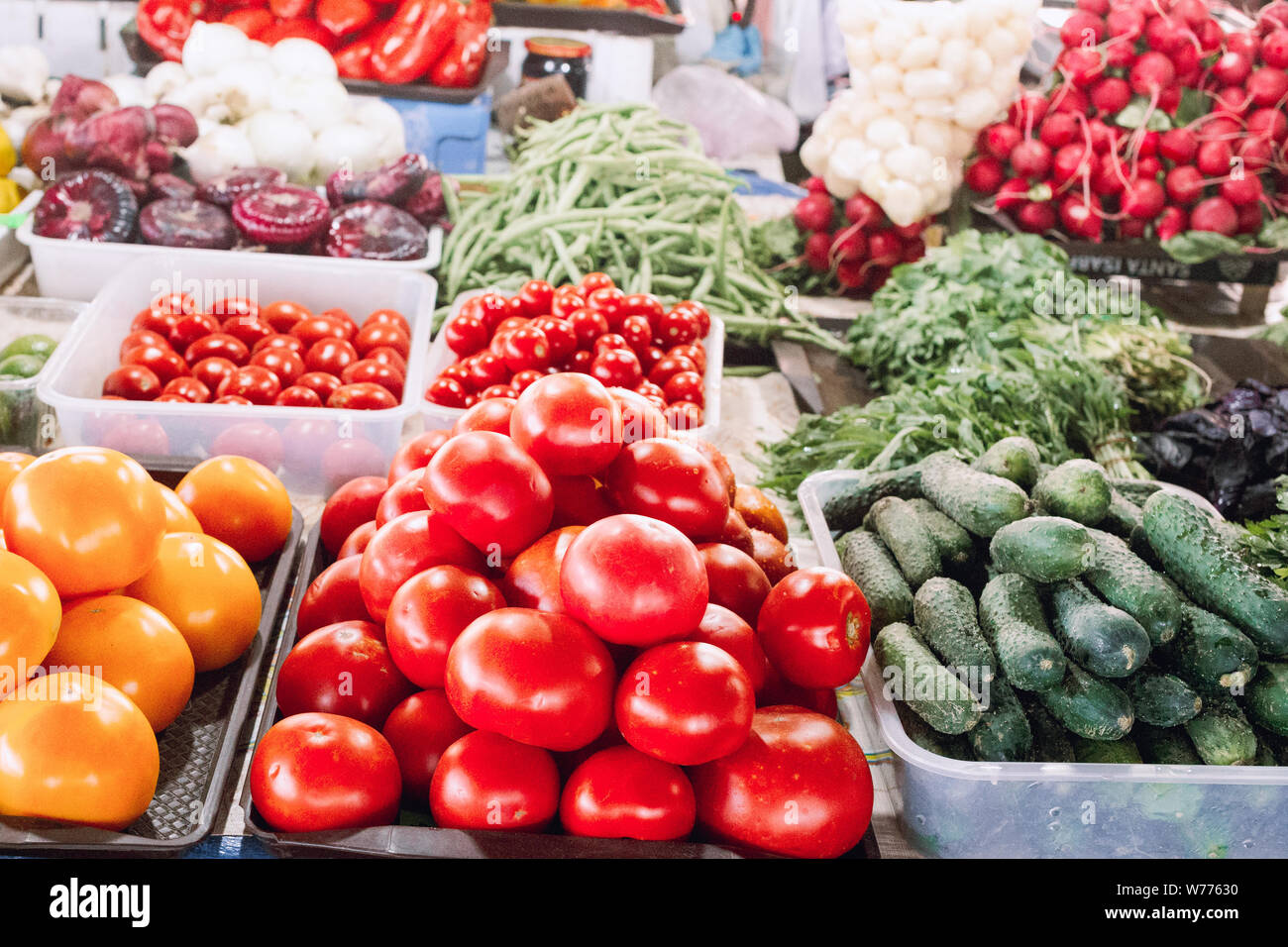 Contatore a un agricoltori street market con pomodori, cipollotti, mais, cavolo, cetrioli, ravanelli, i limoni e le erbe fresche. Pomodori organico sul co Foto Stock