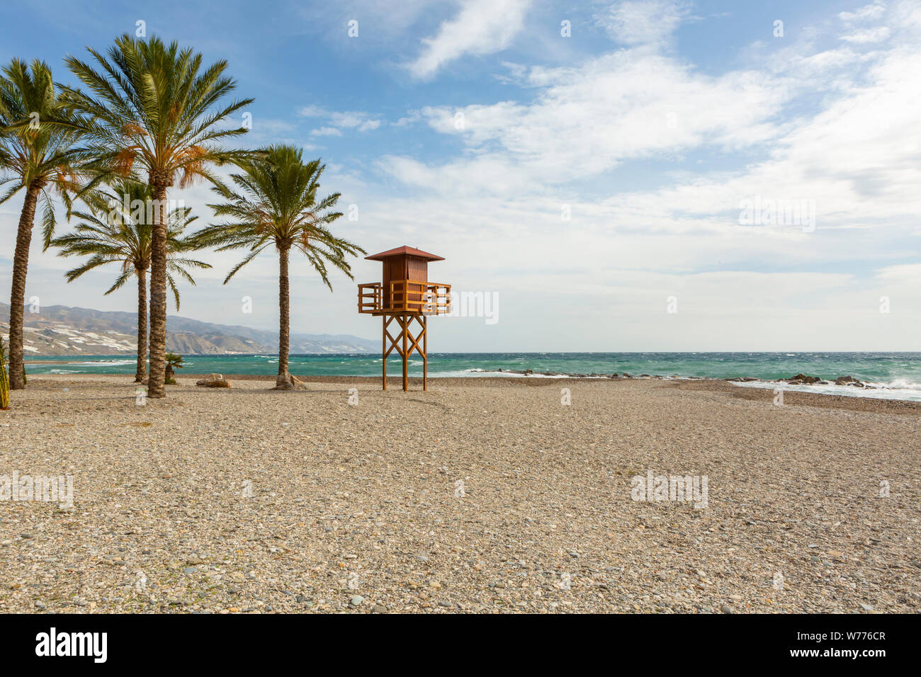 Svuotare la spiaggia sabbiosa in inverno con palme e life guard stand in inverno Foto Stock