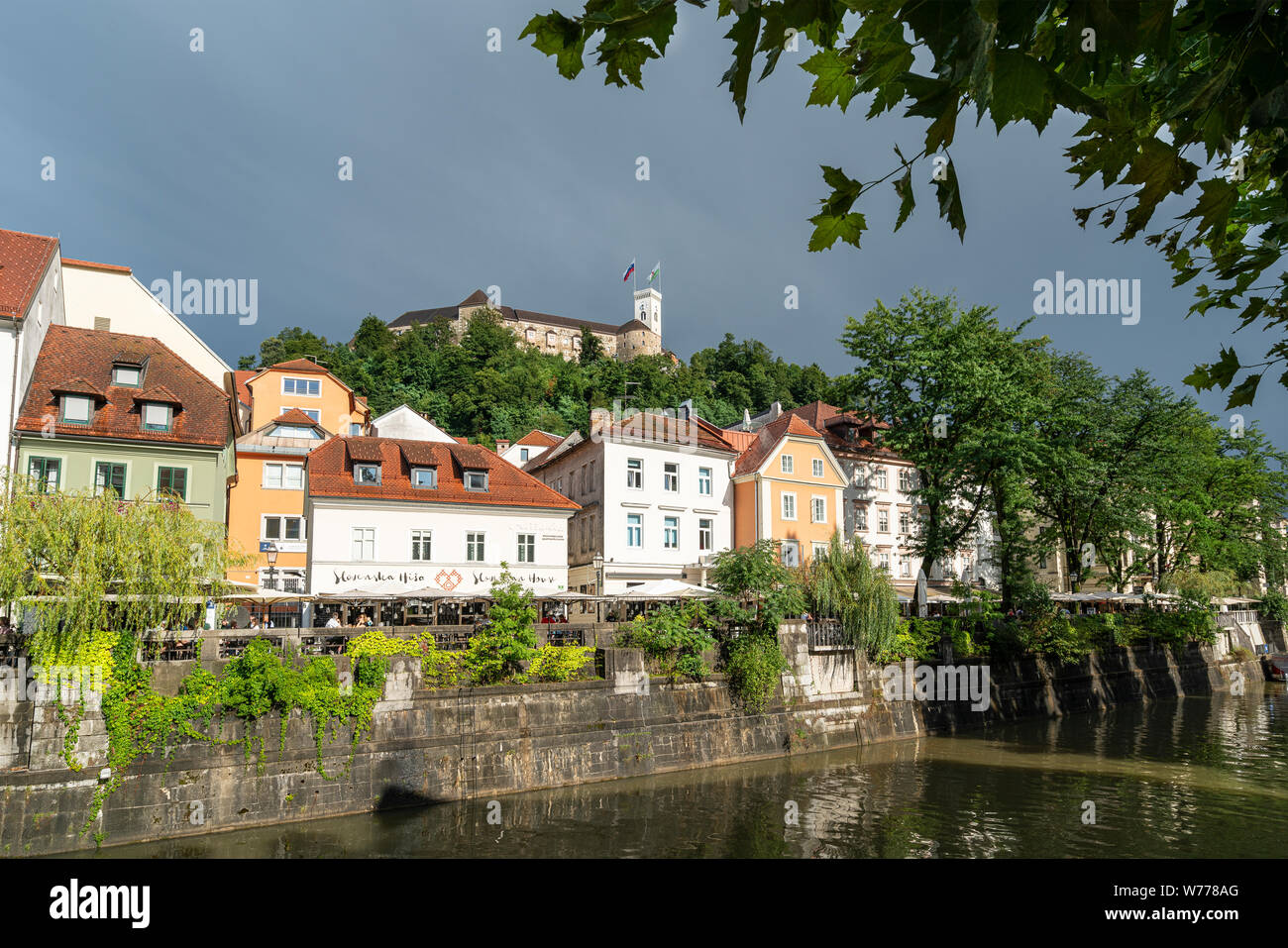 Lubiana, Slovenia. Il 3 agosto 2019. Le case sul fiume Ljubljanica con il castello in background Foto Stock