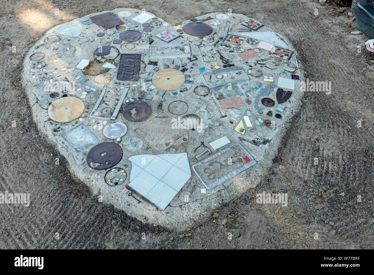 Una porzione del mosaico il marciapiede che si snoda attraverso la nonna Prisbrey bottiglia del villaggio in Simi Valley, California; all'età 60, Tressa Grandma Prisbrey, iniziò il karting bottiglie home dalla città dump per uso come poco costoso materiale da costruzione, inizialmente per un muro tra lei e una vicina Turchia farm. Nel corso del tempo ha trasformato la sua un terzo acri molto rurale nella bottiglia Village, un folk-arte fantasyland di santuari, desiderosi di pozzi, passerelle a mosaico, fontane, follie e strutture 15 tutti realizzati da oggetti trovati. Foto Stock