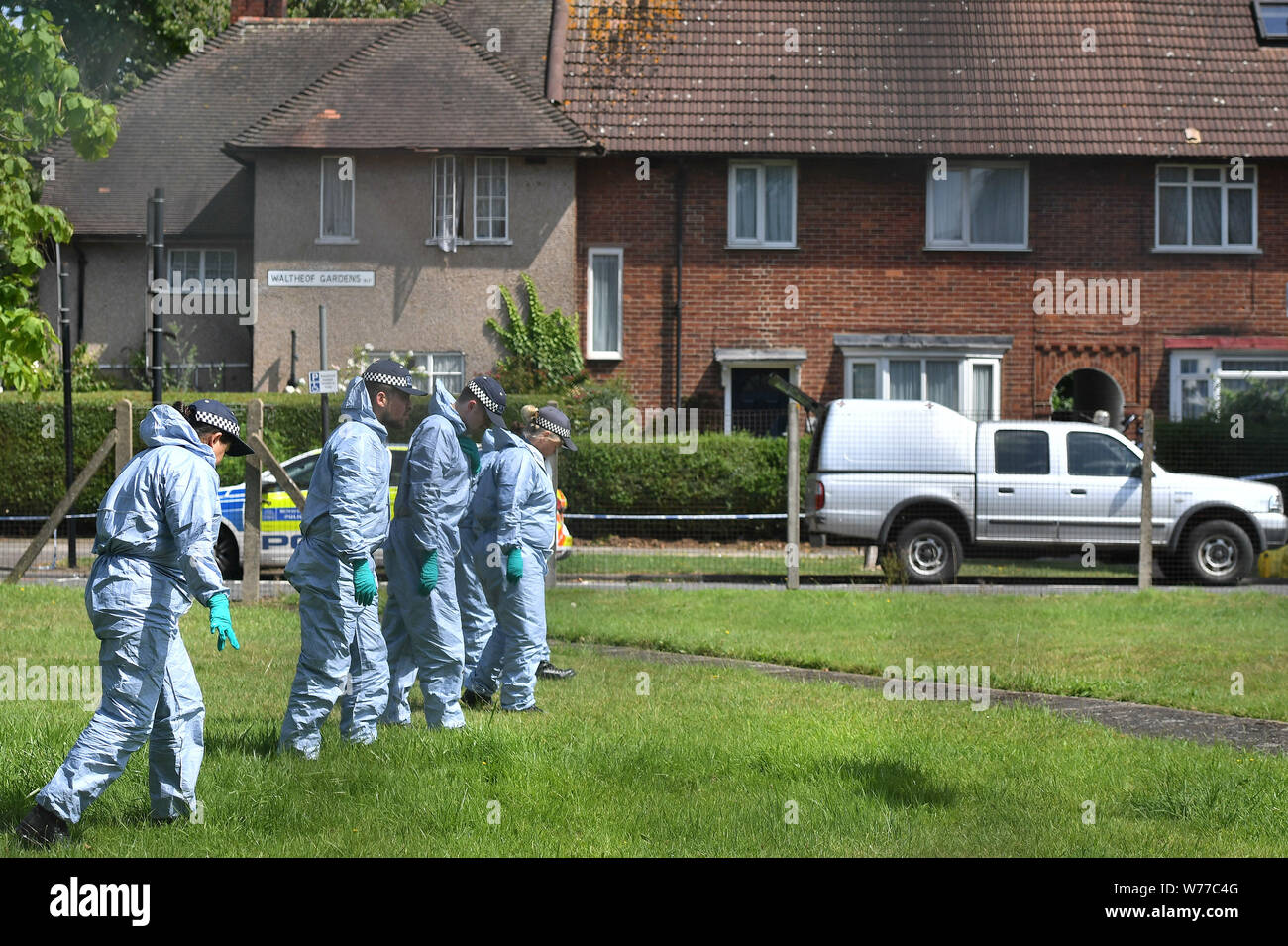 Gli ufficiali di polizia ricerca Waltheof Giardini in Tottenham, nord di Londra dopo un 89-anno-vecchia donna è stato trovato ucciso nella sua casa (dietro). Foto Stock
