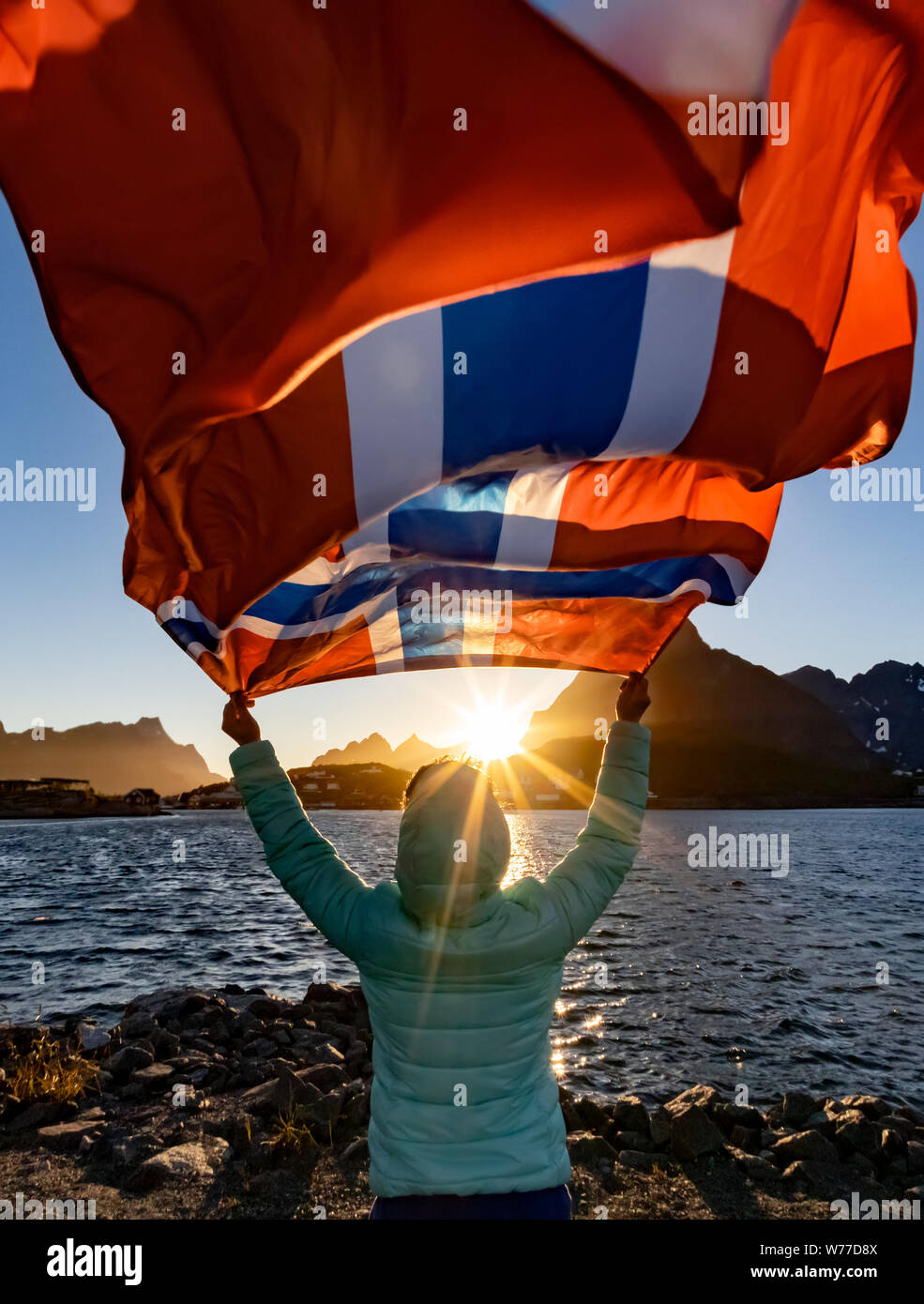 Donna sventolare la bandiera della Norvegia al tramonto sullo sfondo Foto Stock