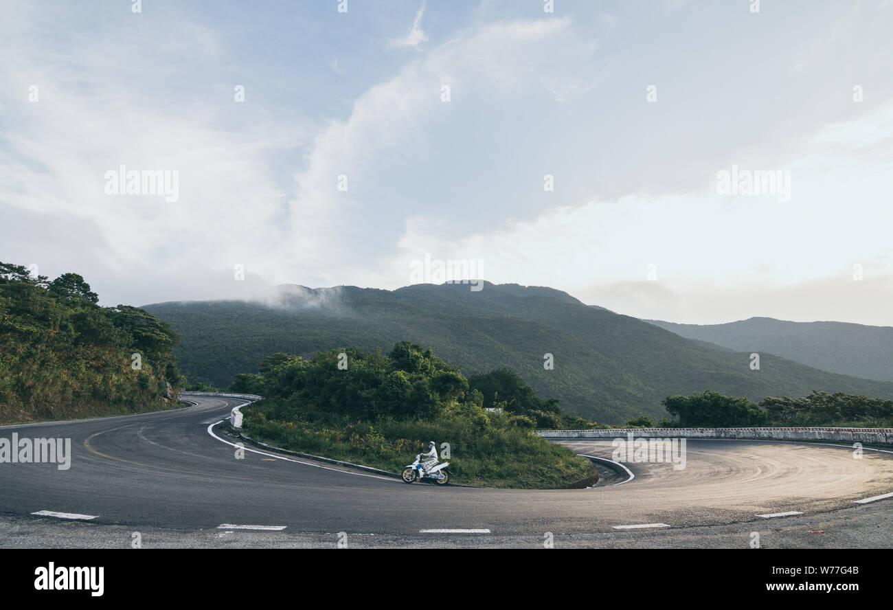 Equitazione donna motocicletta su strade tortuose di Hai Van pass da Hue città di Hoi An, Vietnam. Foto Stock