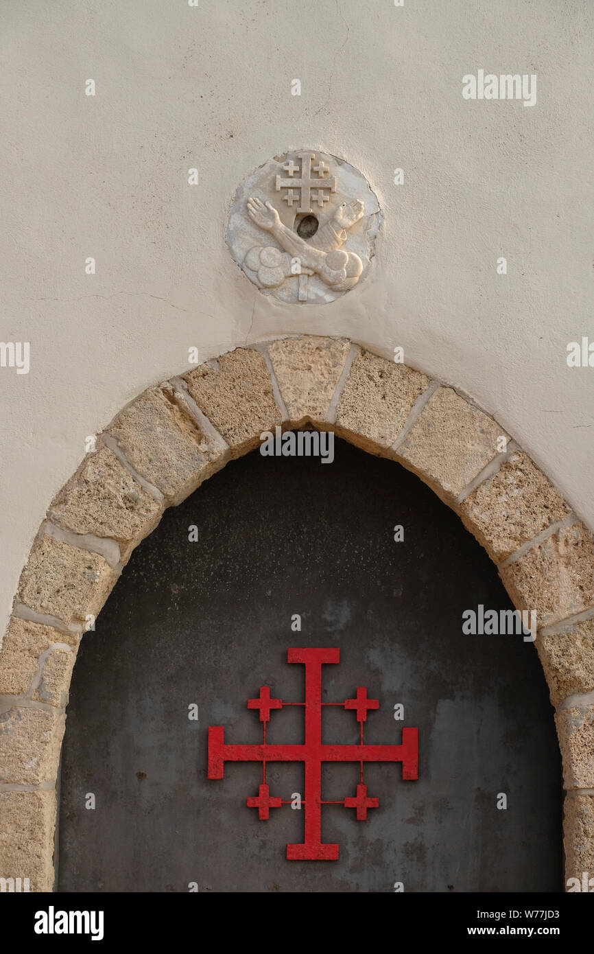 La Croce di Gerusalemme o dei crociati croce con quattro bracci uguali e  quattro piccole croci in ogni angolo è intagliato in ingresso alla chiesa  di San Giovanni Battista costruita dai francescani
