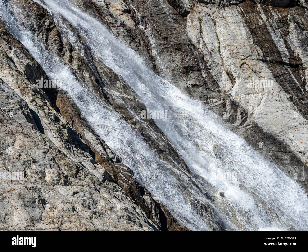 Flusso che scorre su grandi rocce, ghiacciai de l' una de Neuve, valle glaciale su un percorso a piedi da La Fouly a baita di montagna Cabane de l' UNA Neuve, cantone Foto Stock