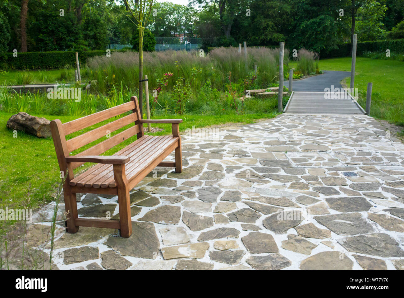 Un banco e pavimentazione ornati a un pubblico giardino paesaggistico situato a Roker Park, Sunderland Foto Stock