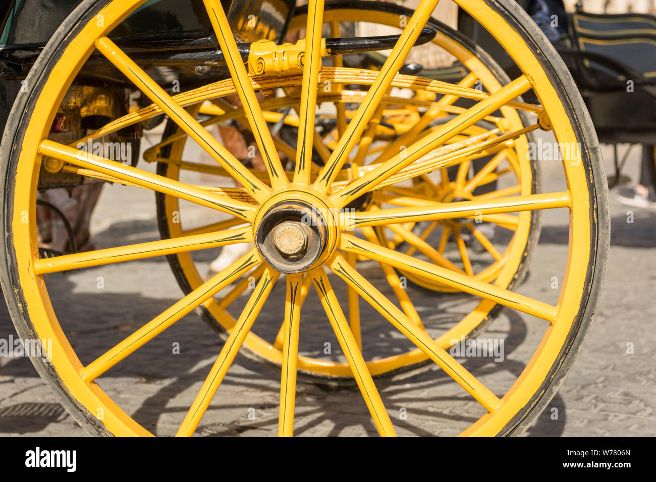Una chiusura del giallo ruote tradizionale di un carro trainato da cavalli a Siviglia Spagna Foto Stock