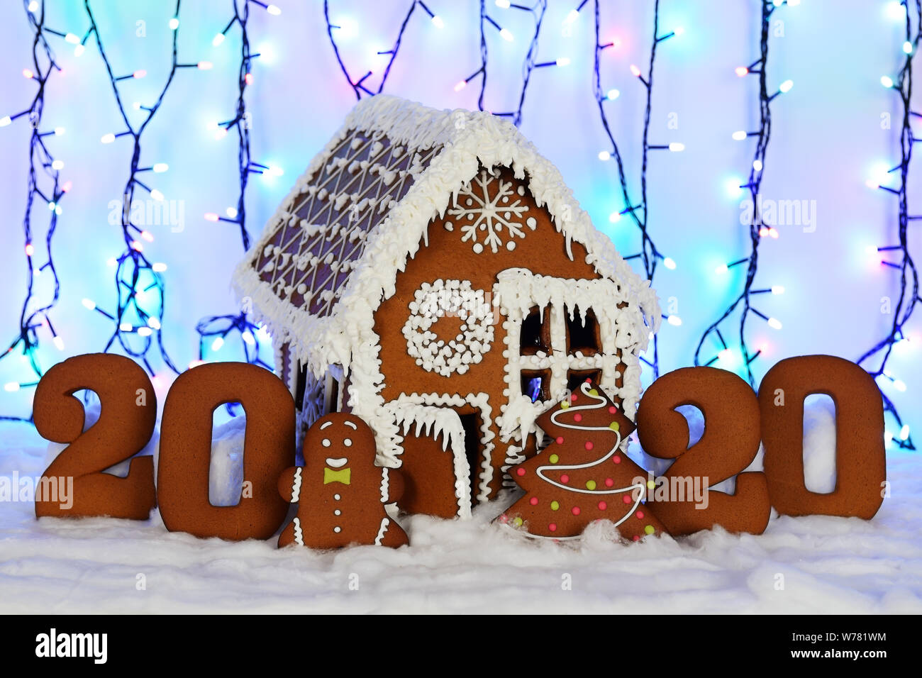 I fatti a mano mangiabile gingerbread house, 2020 iscrizione, piccolo uomo, Nuovo Anno Albero, neve decorazione, ghirlanda di illuminazione di sfondo Foto Stock