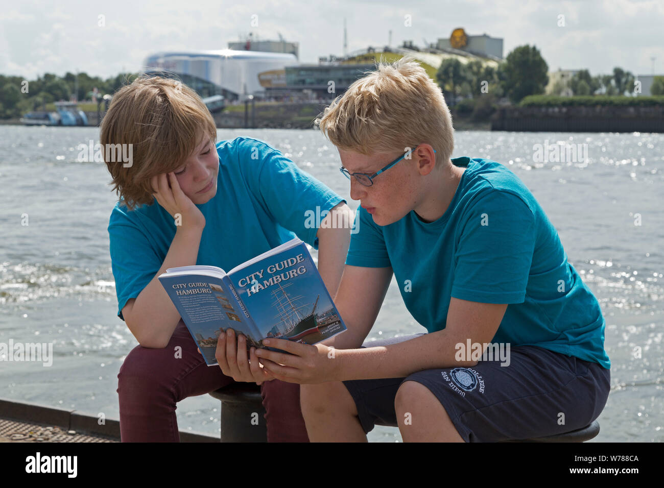 Gli adolescenti durante lo studio della lingua corsa nello studio della loro guida della città accanto al fiume Elba, Amburgo, Germania Foto Stock
