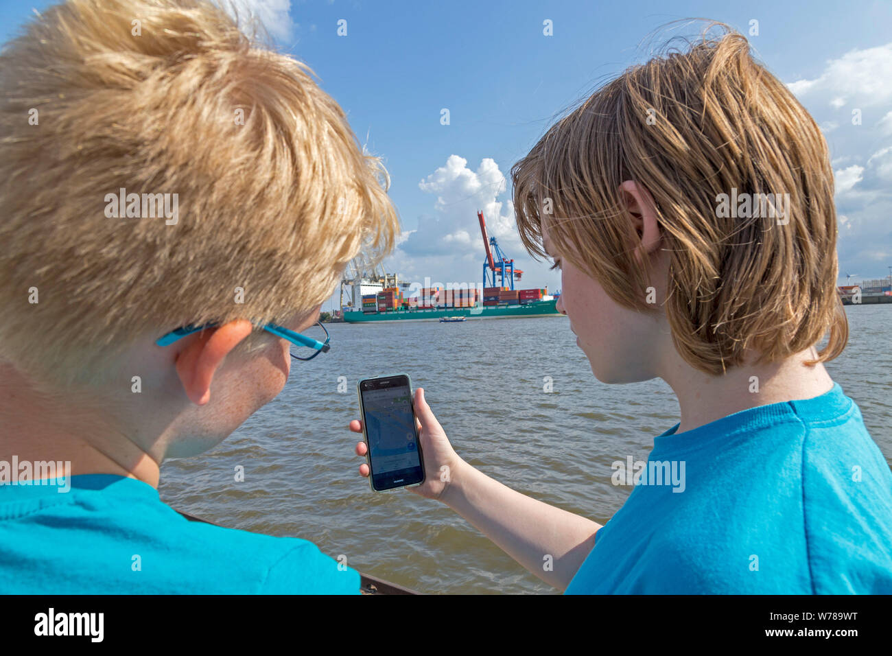 Gli adolescenti durante lo studio della lingua in viaggio utilizzando un telefono cellulare per l'orientamento, Amburgo, Germania Foto Stock