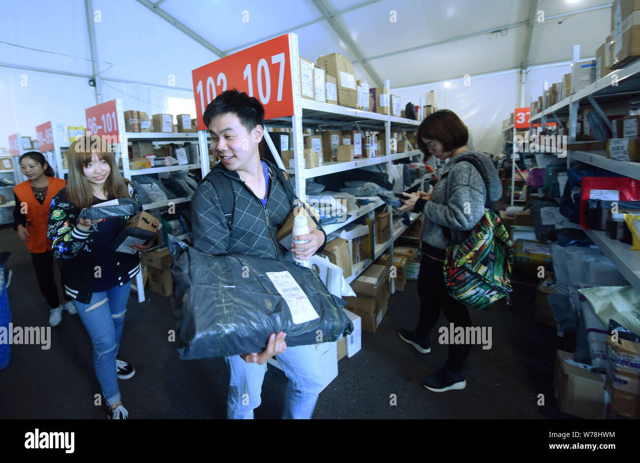 Studenti Cinesi cerca in una massa di pacchi, la maggior parte delle quali sono singole giorno per lo shopping online, in corrispondenza di una tenda temporanea nel Zhejiang University in Hangzh Foto Stock