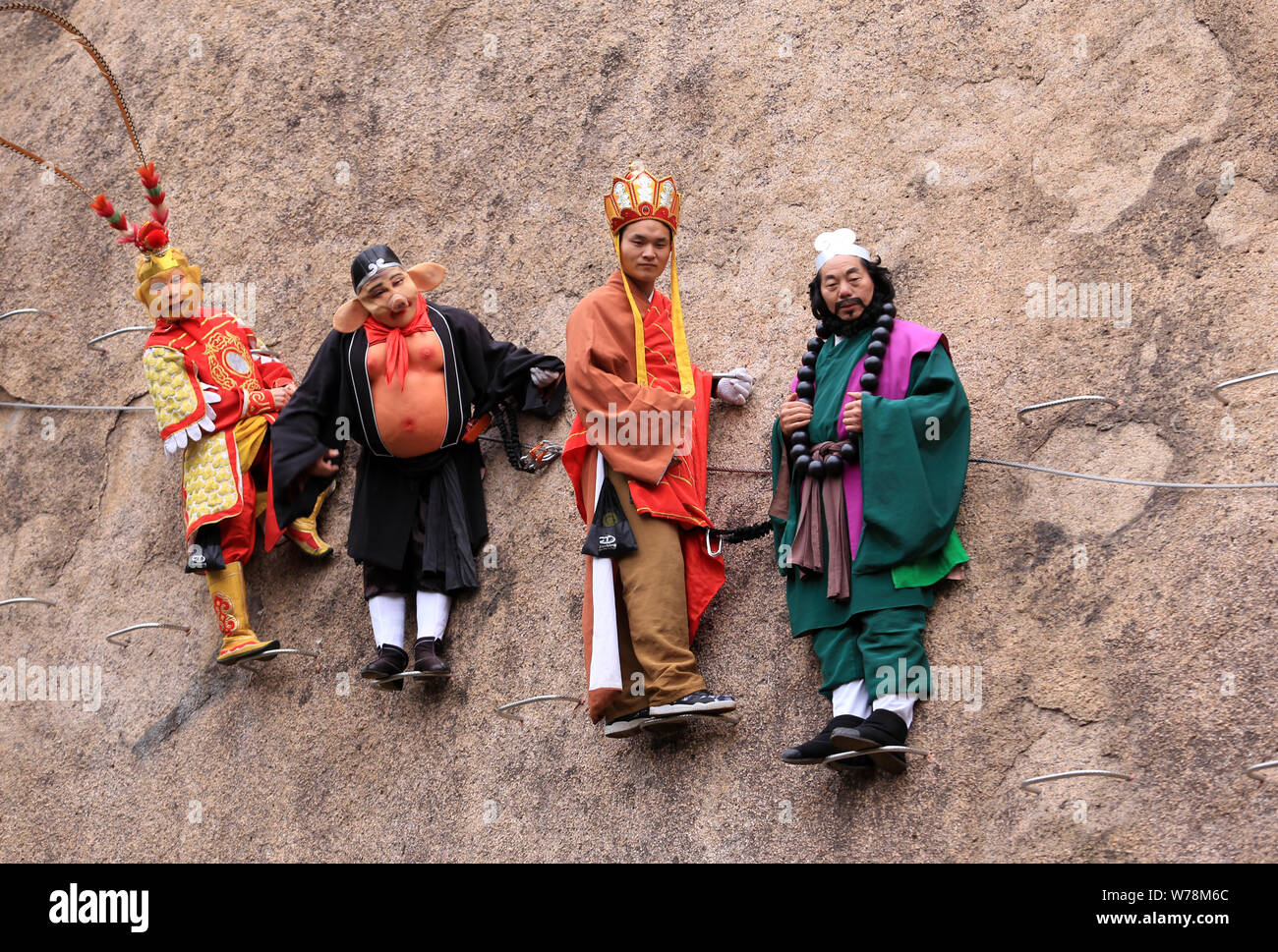 Un personale vestito come personaggi di cinesi serie TV 'viaggio a ovest" posa per foto appesa a una scogliera del Chaya Mountain scenic Foto Stock
