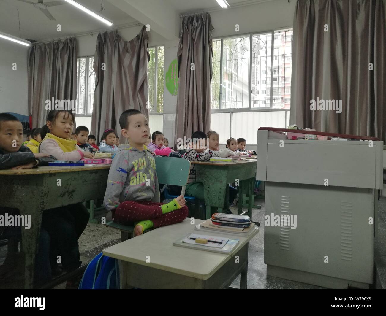 8-anno-vecchio ragazzo cinese Jiang Tianjian nato senza braccia assiste una classe in un aula in Suining city, a sud-ovest della Cina di provincia di Sichuan, 15 Novembe Foto Stock