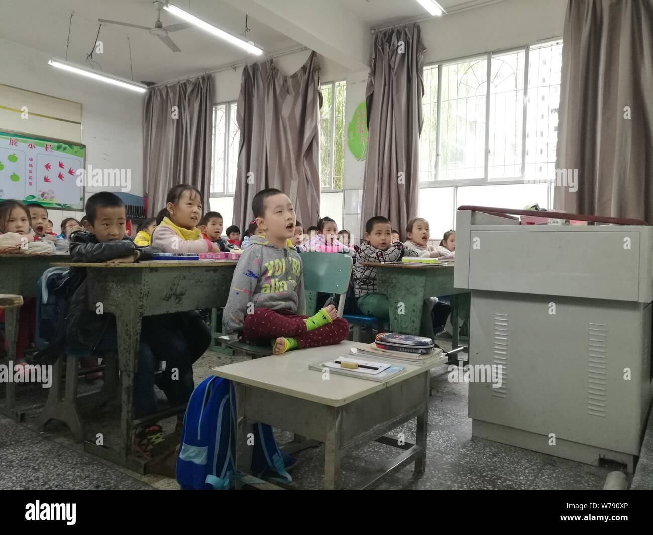 8-anno-vecchio ragazzo cinese Jiang Tianjian nato senza braccia assiste una classe in un aula in Suining city, a sud-ovest della Cina di provincia di Sichuan, 15 Novembe Foto Stock
