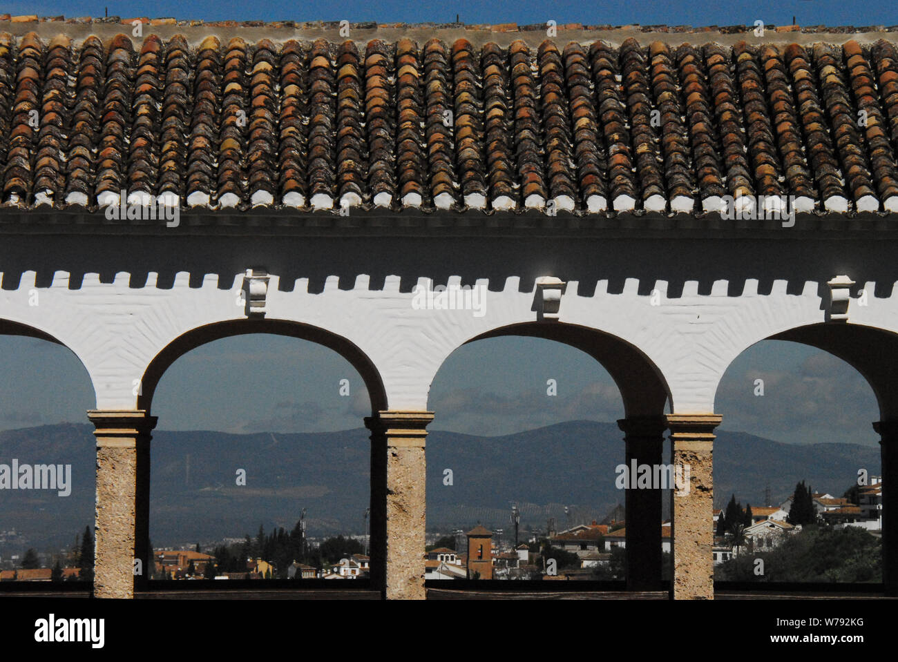 Un bellissimo e la vista unica sulla città di Granada, Spagna attraverso le finestre ad arco sulla terrazza della collina e rabboccato Alhambra Palace. Foto Stock
