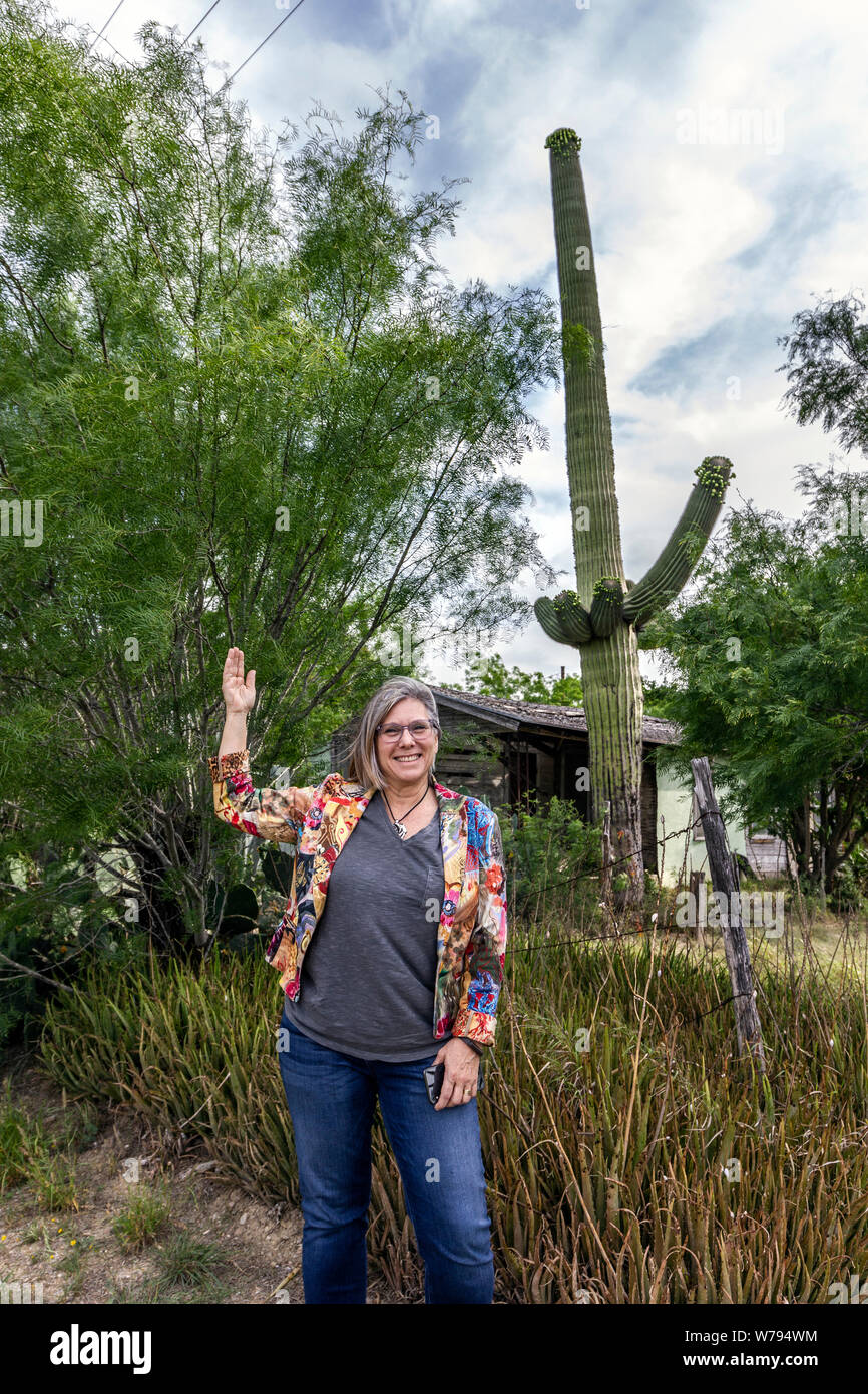 Donna in piedi accanto al gigante cactus Saguaro, Zapata County, Texas, Stati Uniti d'America Foto Stock