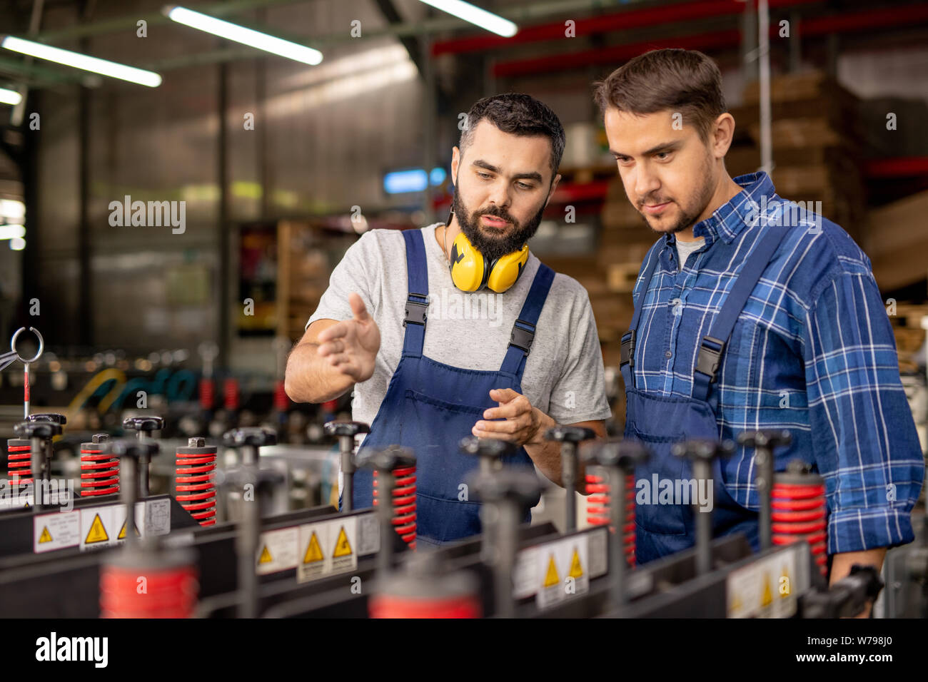 Due giovani uomini di controllo industriale di nuove apparecchiature di elaborazione Foto Stock