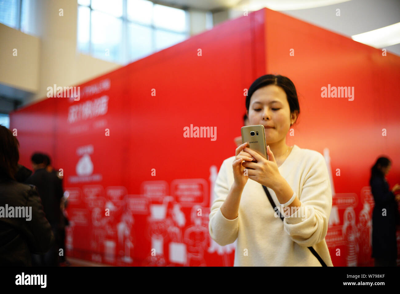 Un residente locale usa il suo smartphone per la cattura di 'Tmall gatti " per ottenere buste rosse attraverso la realtà aumentata (AR) tecnologia durante il 11.11 shopping online Foto Stock