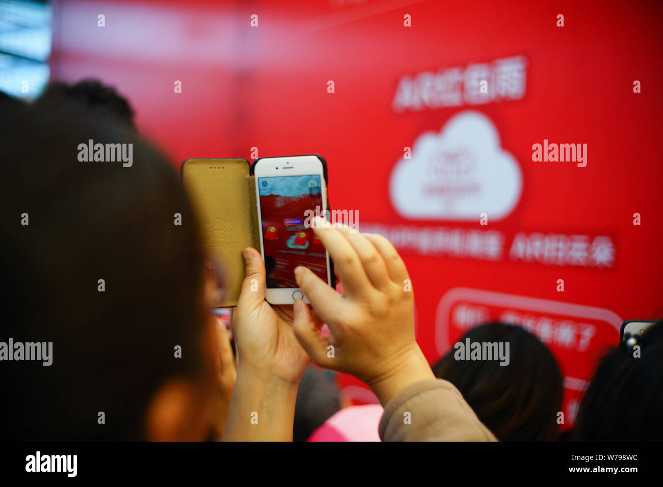 Un residente locale usa il suo smartphone per la cattura di 'Tmall gatti " per ottenere buste rosse attraverso la realtà aumentata (AR) tecnologia durante il 11.11 shopping online Foto Stock