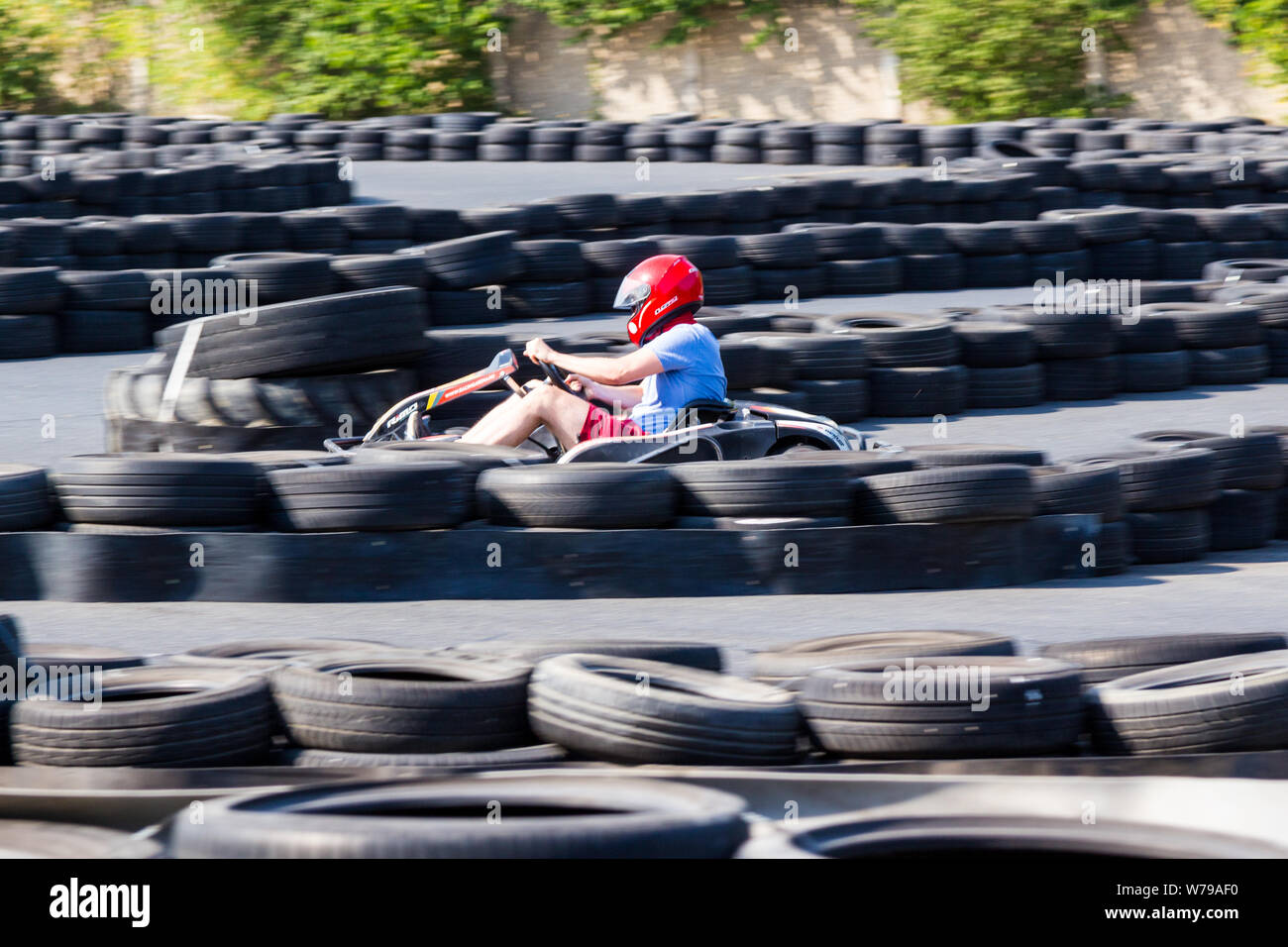 Go-kart in rosso casco racing tra sicurezza barriere di pneumatici Foto  stock - Alamy