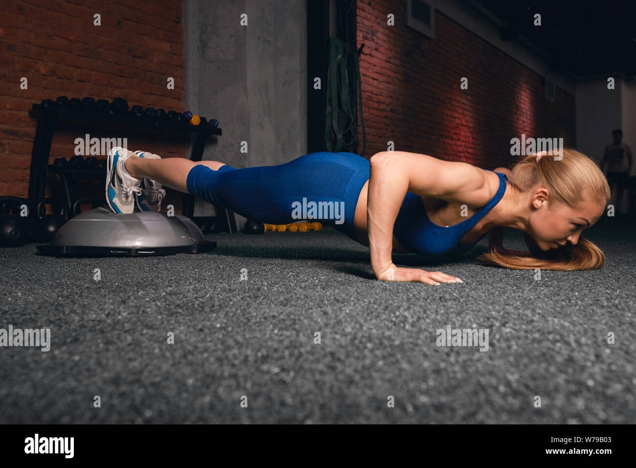 Motivati donna forte facendo premere up, push-up. a lunghezza piena vista laterale foto.wellness e benessere Foto Stock