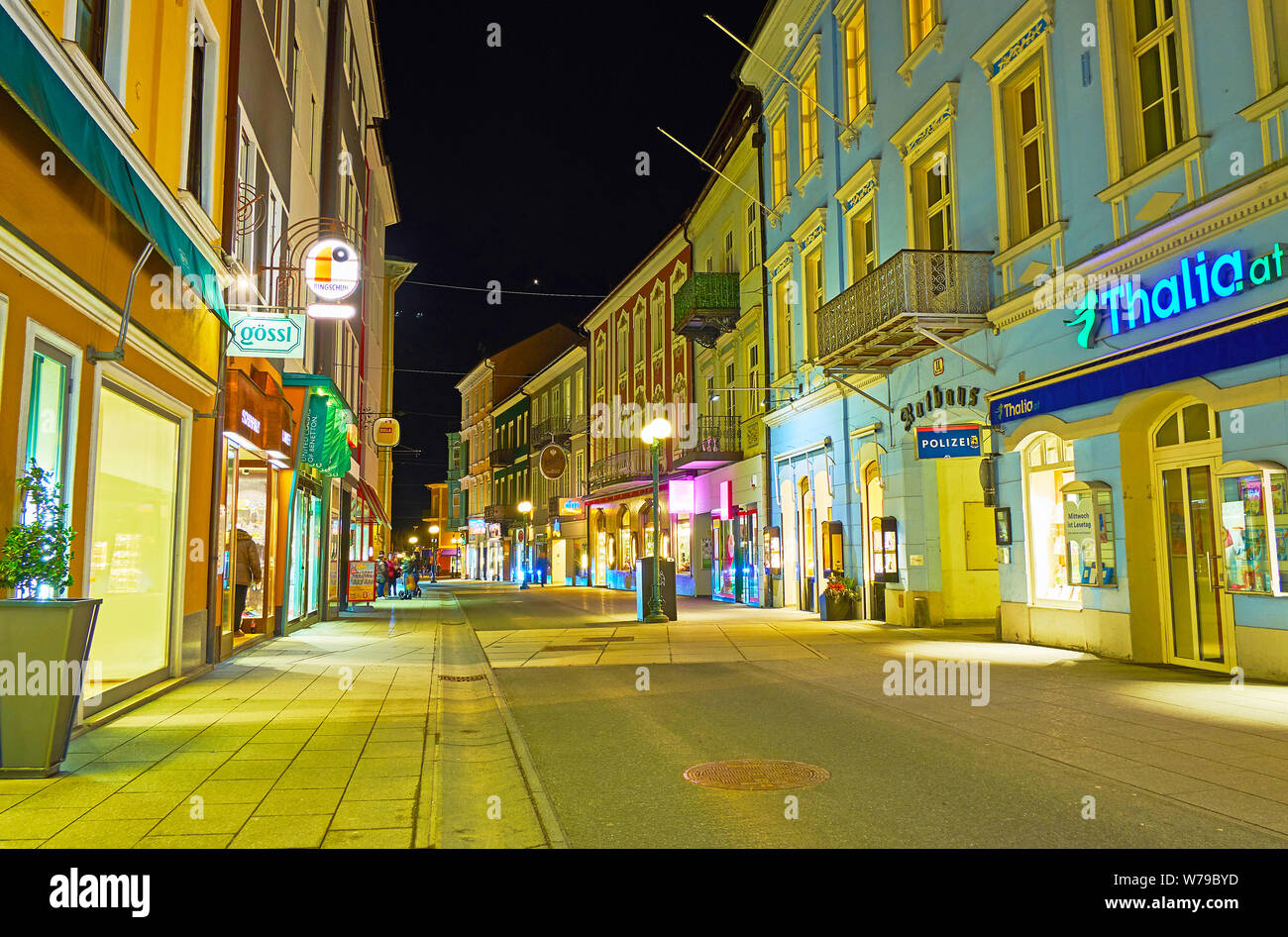 BAD Ischl Austria - 26 febbraio 2019: calma tranquilla passeggiata serale lungo la strada Pfarrgasse con molti colori segni luminosi e vintage lampioni, o Foto Stock
