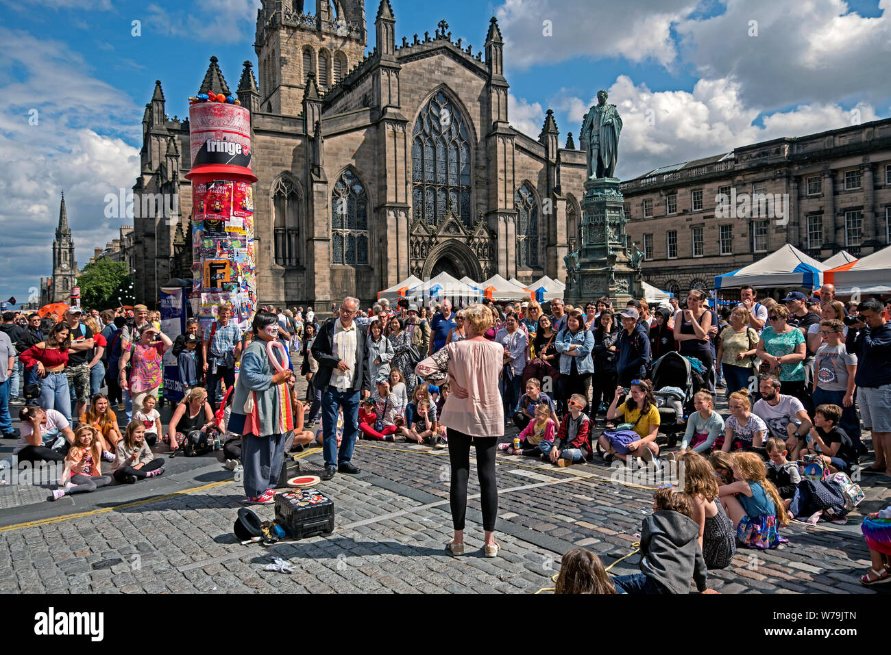 Street performer intrattenere i visitatori al Edinburgh Fringe Festival fuori la cattedrale di St Giles sul Royal Mile di Edimburgo, Scozia, Regno Unito. Foto Stock