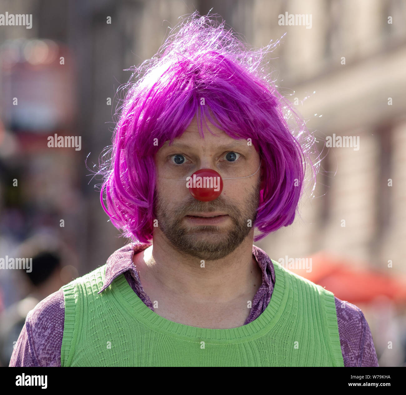 Street esecutore con il naso rosso - Edinburgh Festival Fringe 2019 - Il Royal Mile di Edimburgo, Scozia, Regno Unito. Foto Stock