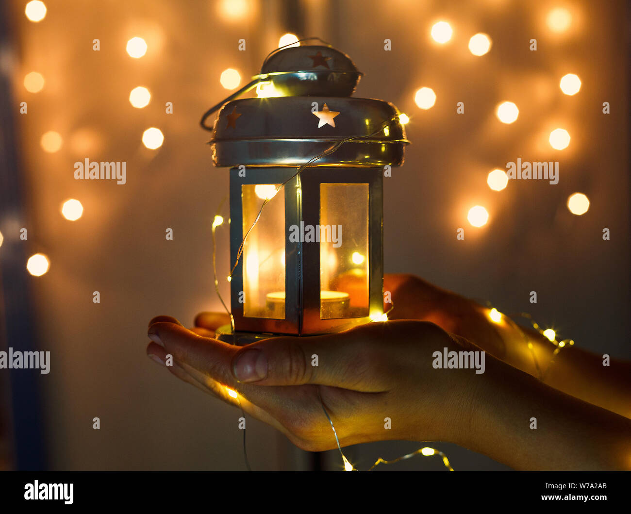 Kids detiene il Natale lanterna in mani sulle luci di sfondo bokeh di fondo. Anno nuovo concetto celebrazione festosa umore Foto Stock