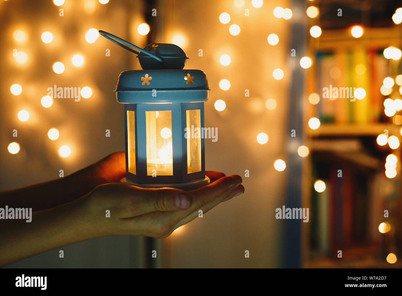 Kids detiene il Natale lanterna in mani sulle luci di sfondo bokeh di fondo. Anno nuovo concetto celebrazione festosa umore Foto Stock