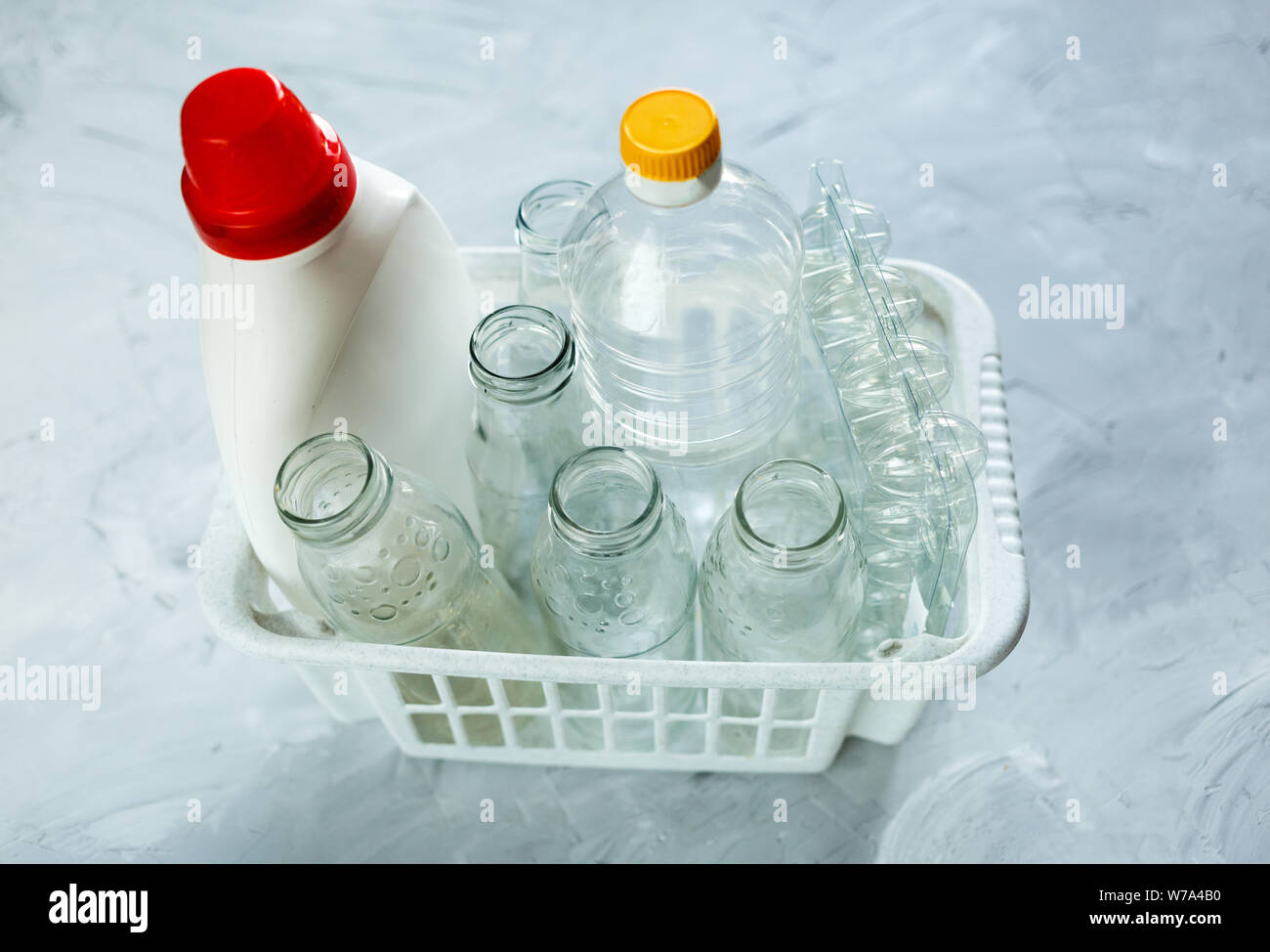 Piatto di laici diversi rifiuti pronti per il riciclaggio nel cestello di bianco. Plastica, vetro, carta. Responsabilità Sociale, ecologia care, riciclaggio a casa Foto Stock
