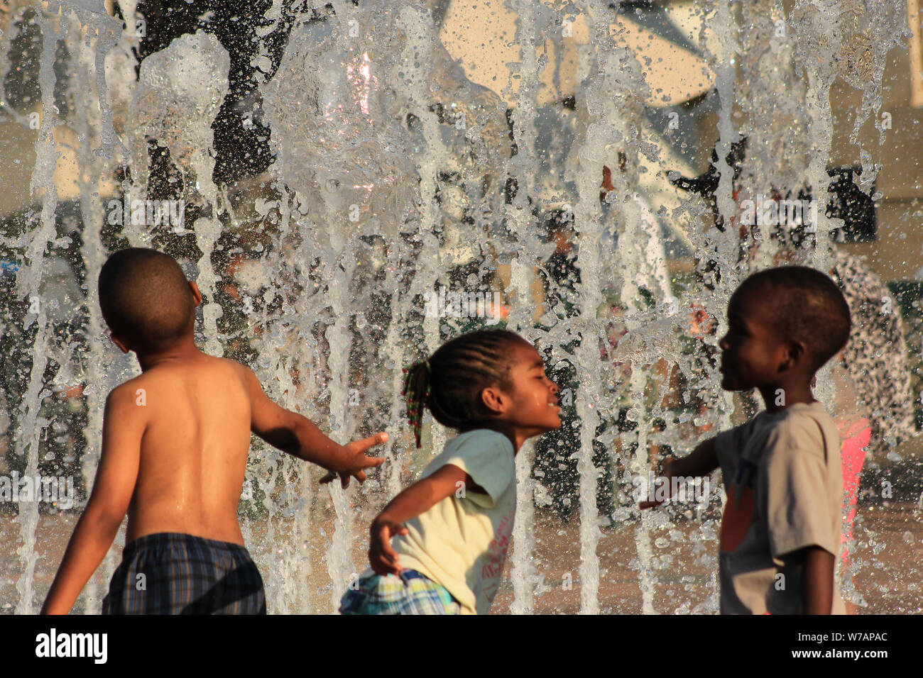 Bambini godendo interactive fontane ad acqua in estate Foto Stock