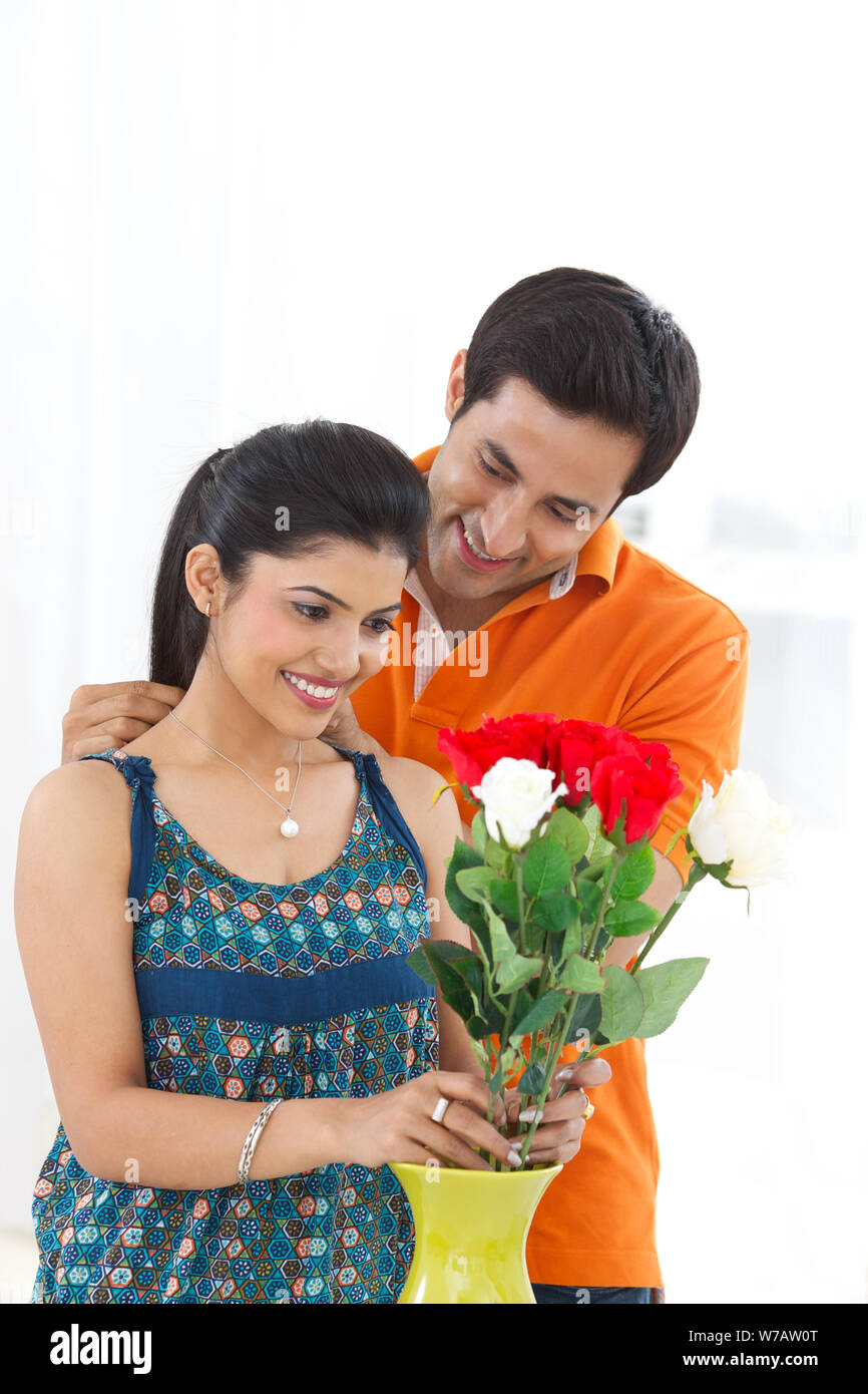 Young man putting on necklace around his wife neck Foto Stock