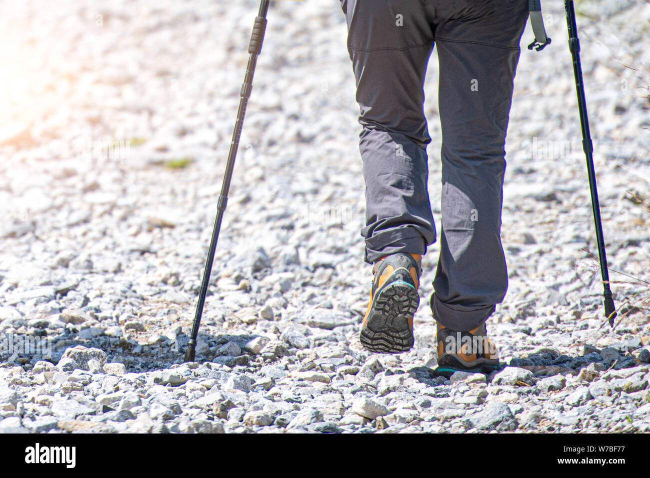 Dettaglio del camminatore di montagna su terreni sassosi road con bastoncini nordic walking Foto Stock