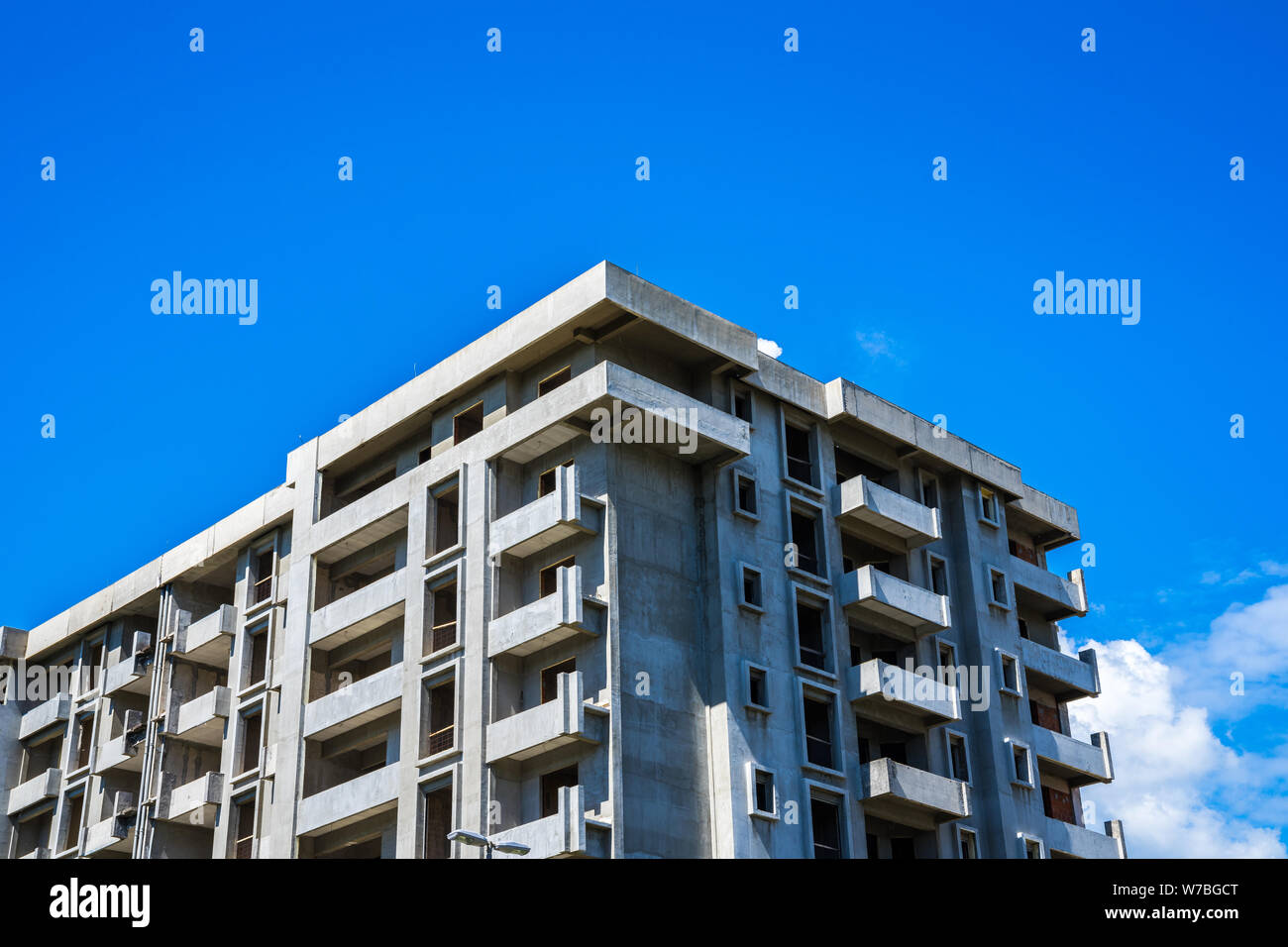 Involucro dell edificio in calcestruzzo di un enorme edificio di appartamenti con molti alberghi sotto il cielo blu Foto Stock