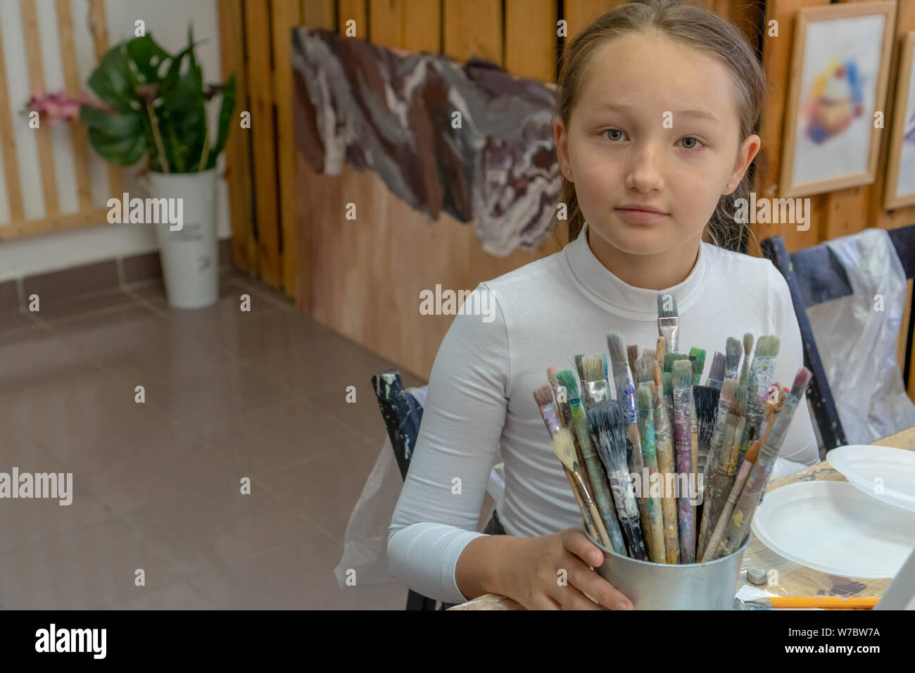 Un insieme di diversi pennelli colore nelle mani della ragazza. Interno della scuola di arte per i bambini di disegno. La creatività e il concetto di popolo Foto Stock