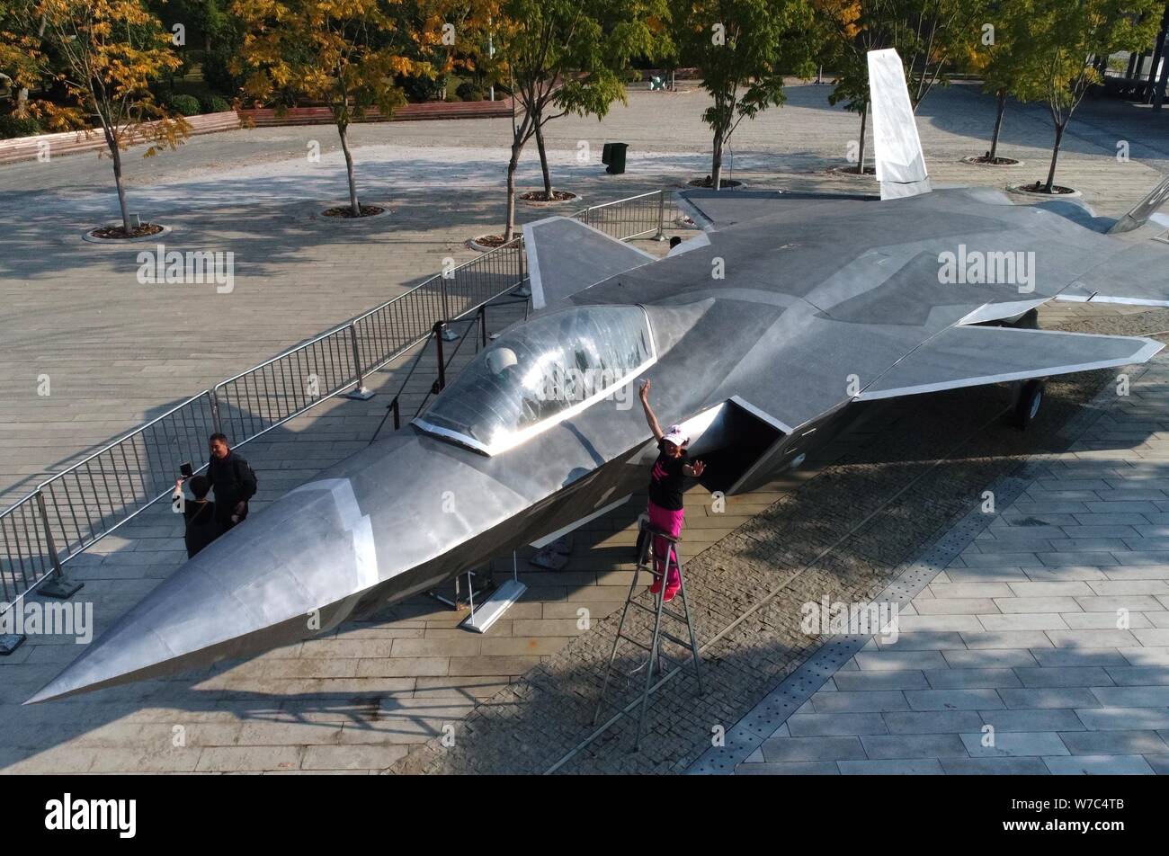 Un visitatore prende le foto con il modello a grandezza del J-20 Stealth Fighter Aircraft cinese di PLA (popoli dell Esercito di Liberazione) Air Force costruito da chi Foto Stock