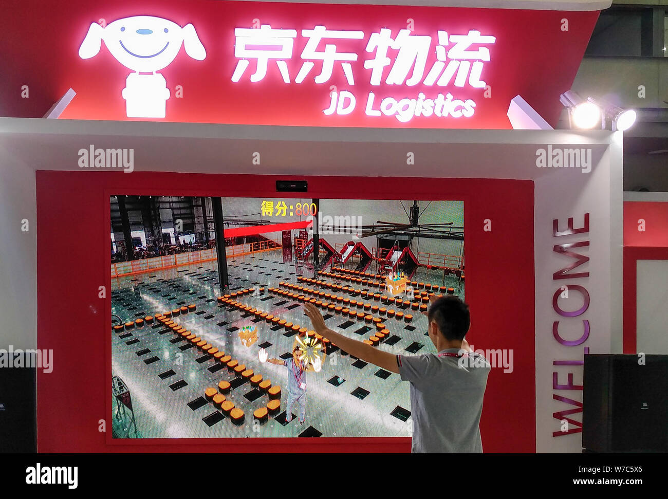 --FILE--un visitatore viene visto allo stand di JD Logistica cinese del rivenditore online JD.com durante una mostra nella città di Shenzhen, nel sud della Cina di Guangdon Foto Stock