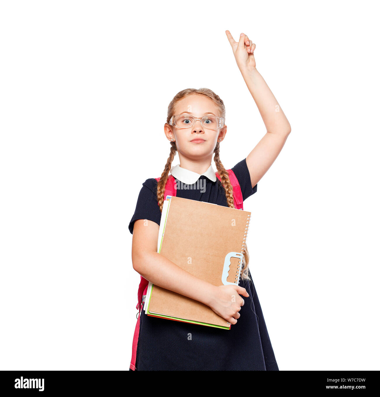 8 anni schoolgirl con uno zaino che indossano uniformi isolato permanente su uno sfondo bianco. Pronti per la scuola Foto Stock