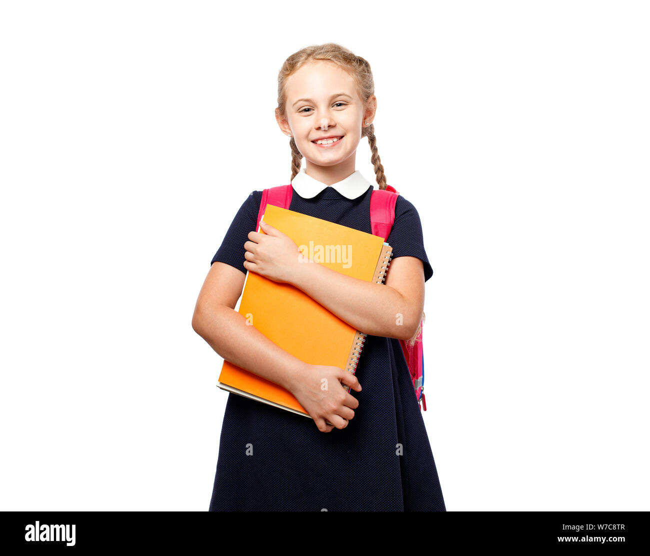 Allegro 8 anni schoolgirl con zaino indossano uniformi isolato permanente su sfondo bianco. Pronti per la scuola Foto Stock