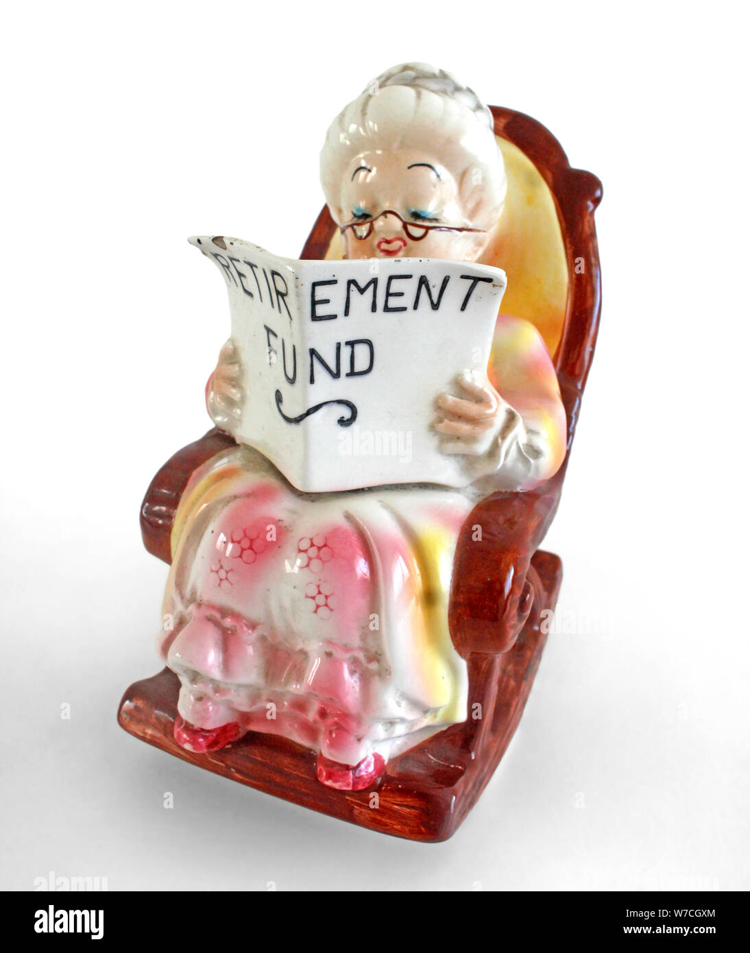 Figurina di un senior signora lettura fondo di previdenza carte mentre è seduto su una sedia a dondolo. Foto Stock