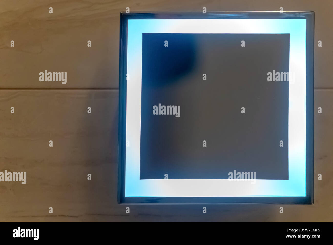 Forma quadrata specchio con luce a LED mese sul muro bianco nella toilette. Specchio quadrato in bagno. Foto Stock