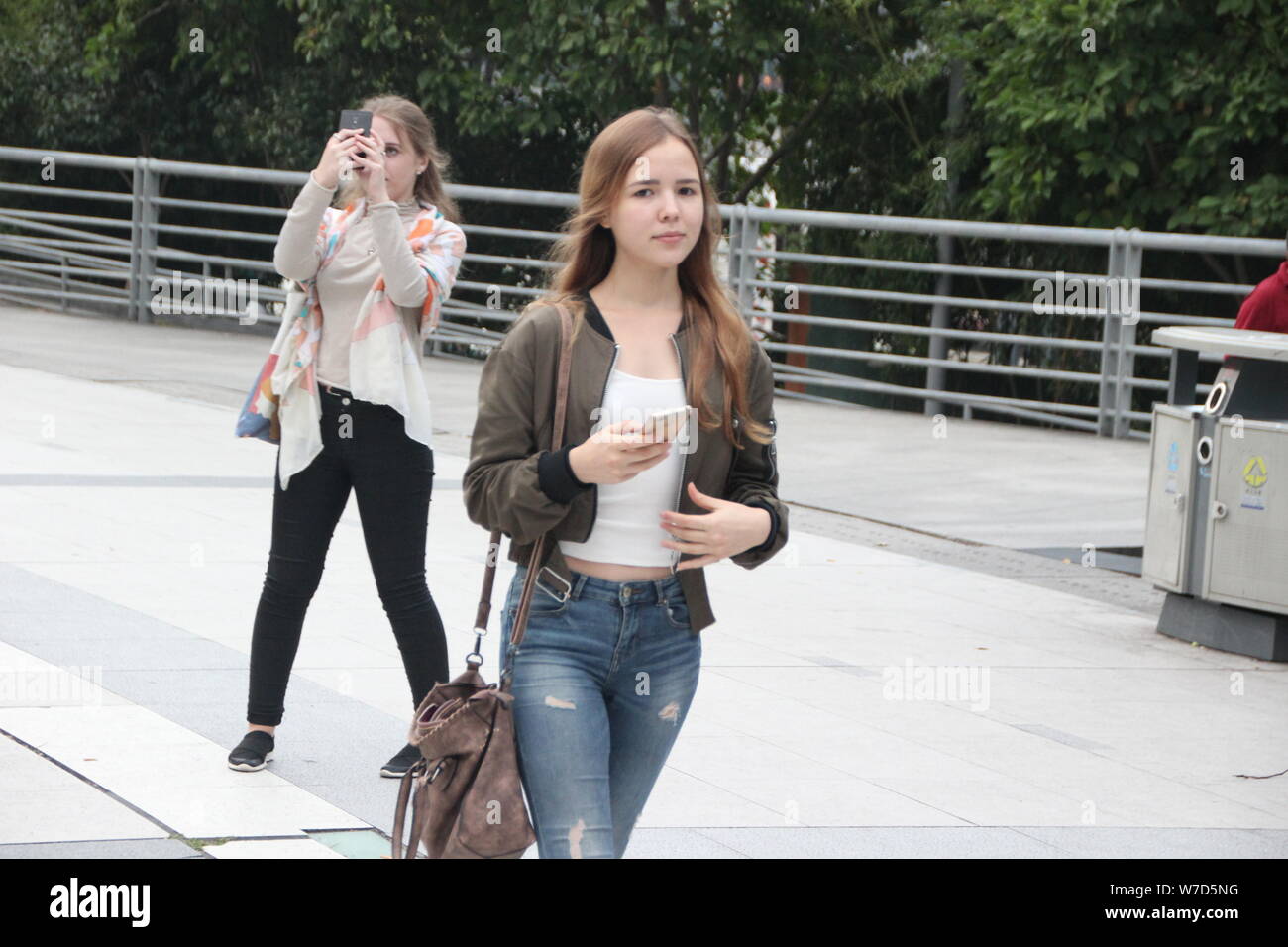 Un pedone che indossa un cappotto contro l'ondata di freddo passeggiate su una strada durante la giornata nazionale e Mid-Autumn Festival holiday in Hangzhou, Oriente Cina Foto Stock