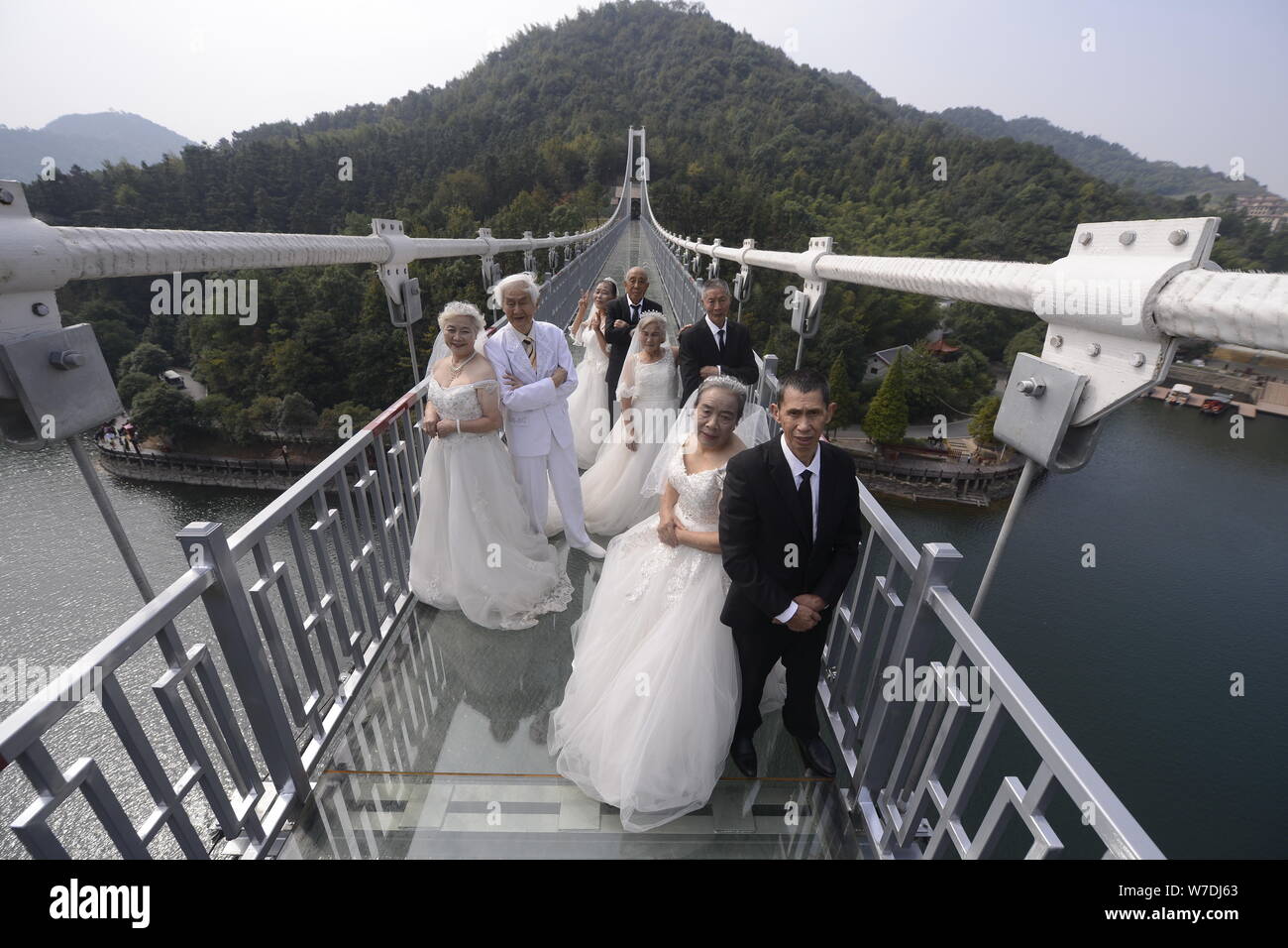 Quattro coppie di età superiore ai 80 di scattare delle foto su una lastra di vetro con fondo di ponte che è 100 metri sopra il livello del suolo per celebrare il loro golden gli anniversari di matrimonio Foto Stock