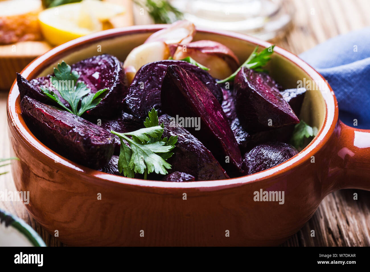 Yogurt dip con prezzemolo e aneto e succo di limone servita su tavola in legno rustico con arrosti di barbabietole, pane e limone fresco acqua, vicino, vegan impianto bas Foto Stock