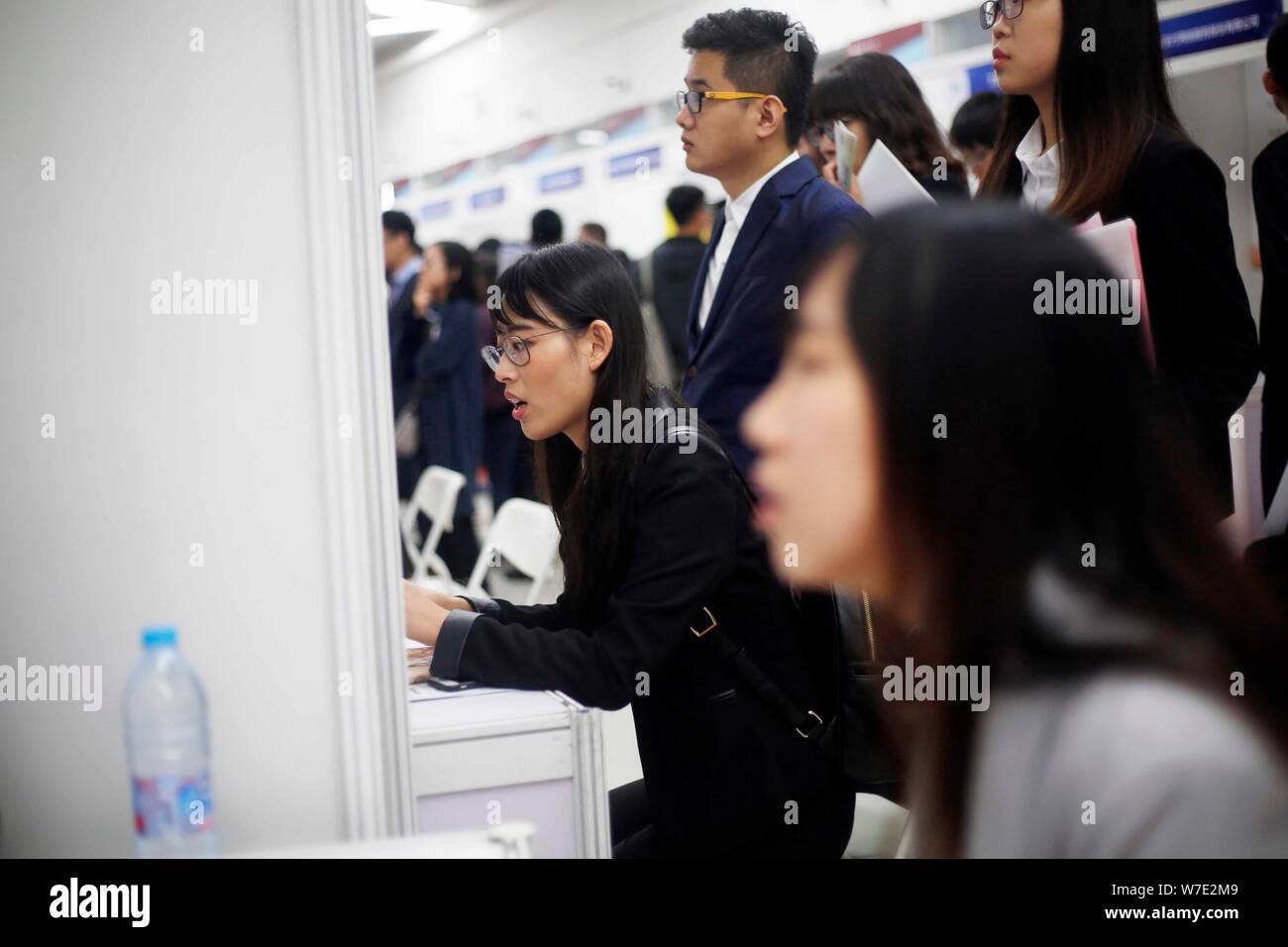 Il Cinese in cerca di lavoro parla con intervistatori in cerca di occupazione nel settore finanziario a una fiera del lavoro in Cina a Shanghai, 16 ottobre 2017. Un recente su Foto Stock