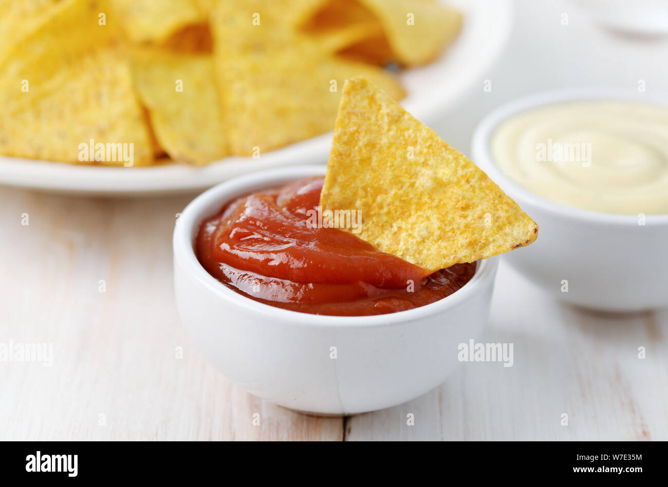 Close up messicano di nachos patate fritte con ketchup su bianco tavolo in legno Foto Stock